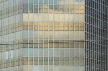 Glasfassade eines modernen Bürogebäudes mit Wolkenspiegelung