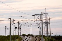 Geschwungene Bahnstrecke mit Oberleitungen in der Abenddämmerung