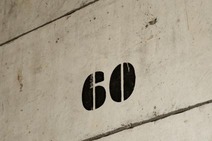 Schwarze Schablonenzahl 60 auf einer abgenutzten Betonwand