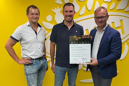 Drei Männer halten ein Nachhaltigkeitszertifikat für Rauch Fruchtsäfte