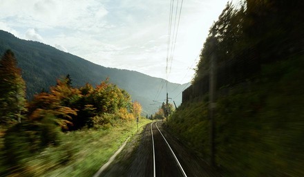 Blick entlang einer Bahnstrecke durch eine bewaldete Berglandschaft