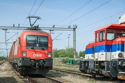 ÖBB-Lokomotive auf einem Gleis neben einer Rangierlok auf einem Bahnhofsgelände