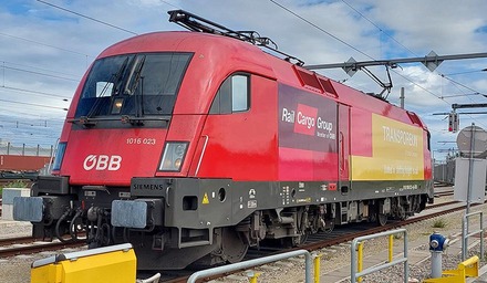 ÖBB Lokomotive der Rail Cargo Group mit Transporeon Branding auf Bahnhofsgleis