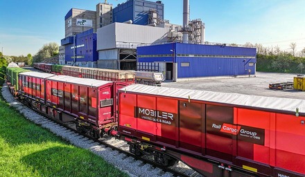 MOBILER Transportbehälter der Rail Cargo Group auf Bahnwagen vor Industrieanlage
