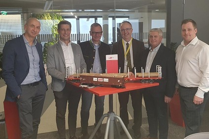 Vertreter der Rail Cargo Group und von Papierholz Austria mit Modell eines Holztransport-Güterwagens