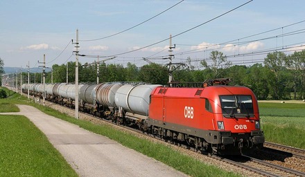 ÖBB Güterzug mit Kesselwagen fährt durch ländliche Landschaft