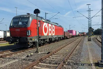 ÖBB Lokomotive zieht Container-Güterzug auf elektrifizierter Bahnstrecke