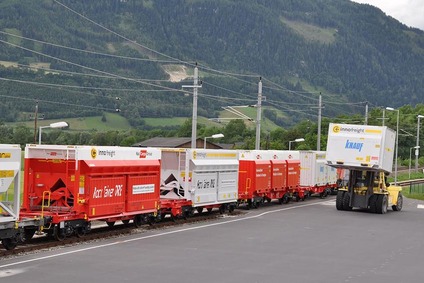 InnoWaggon-Einheiten stehen auf dem Gleis, während ein Gabelstapler einen Container für den kombinierten Verkehr bewegt