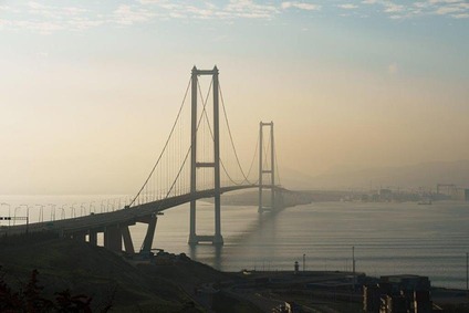 Brücke in der Türkei über einer weiten Bucht bei Sonnenaufgang mit ruhigem Wasser und Dunst