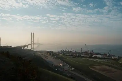Bridge in Turkey spanning a coastal bay, with a port terminal and cranes along the shoreline