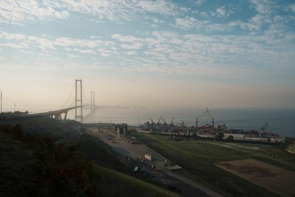 Bridge in Turkey spanning a coastal bay, with a port terminal and cranes along the shoreline