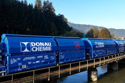 Spezielle Donau Chemie Wagen überqueren eine Brücke über einen Fluss in bewaldeter Landschaft