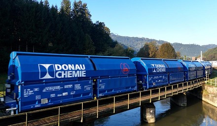 Blaue Donau Chemie Wagen transportieren chemische Güter über eine Brücke in ländlicher Umgebung