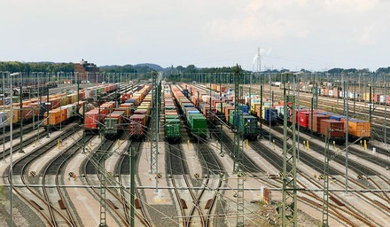 Großer Güterbahnhof mit zahlreichen Containerzügen auf mehreren Gleisen