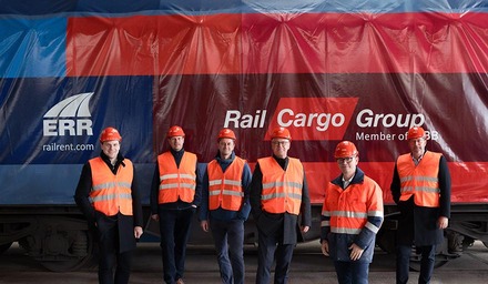 Sechs Vertreter mit Helmen und Warnwesten vor einem Shimmns-Güterwagen von ERR und Rail Cargo Group