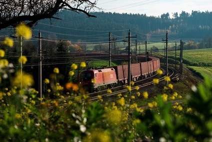 ÖBB Güterzug der Rail Cargo Group fährt durch eine ländliche Landschaft mit Wiesen und Wäldern