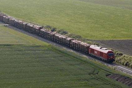 Langer Güterzug der Rail Cargo Group auf einer Bahnstrecke durch offene Felder