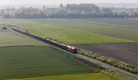 ÖBB Güterzug der Rail Cargo Group fährt durch eine landwirtschaftliche Landschaft mit Feldern