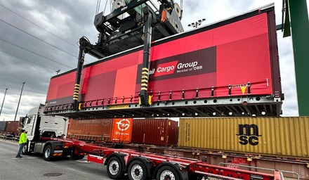 Kran verladen einen Rail Cargo Group Wechselaufbau für multimodalen Stahltransport im Terminal