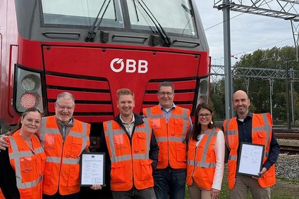 Mitarbeitende der Rail Cargo Group mit Sicherheitswesten vor einer roten ÖBB-Lokomotive an einer Bahnstrecke