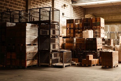 Gestapelte Paletten, Kisten und Gitterboxen in einer Lagerhalle