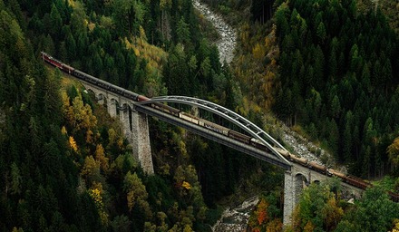 Güterzug überquert Brücke in einem Tal