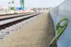 Green brake shoe against a freight wagon beside railway tracks in a terminal