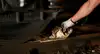 Hand setzt Hemmschuh an ein Güterwagenrad auf dem Gleis