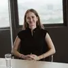 Praktikantin Laura sitzt in einem Besprechungsraum mit Blick über die Stadt.