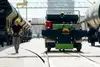 Rail worker walking beside shunting vehicle and freight wagons at a railway yard.