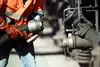 Worker connecting a hose in the mineral oil sector.