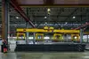 Warehouse in Italy with crane and stacked metal pipes