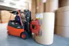 Warehouse Lenzing with a forklift operator moving large paper rolls