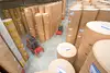 Warehouse Vienna Freudenau with stacked paper rolls and forklifts in motion