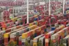 Containerterminal mit gestapelten Containern und Kränen.