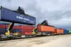 Containerumschlag in Bratislava mit Reachstackern, die Seecontainer auf Güterwagen verladen
