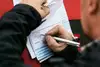 Person signing transport documents on a clipboard