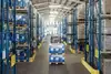 Warehouse in Austria with shelves, pallets and a forklift in operation.