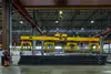 Heavy-duty crane lifting steel beams in Rail Cargo Group warehouse in Italy