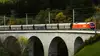 ÖBB Güterzug auf einer steinernen Bogenbrücke in einer Waldlandschaft