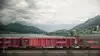 Rendering von Rail Cargo Group Güterwagen vor einem See mit alpiner Berglandschaft und Dorf im Hintergrund