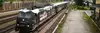 Rail Cargo Group locomotive with Red Bull branding pulling a train through a station area