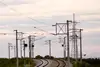Geschwungene Bahnstrecke mit Oberleitungen in der Abenddämmerung