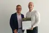 Zwei Männer halten ein Nachhaltigkeitszertifikat für JCL Logistics