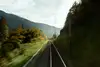 Bahnstrecke in einer kurvigen Alpenlandschaft mit Herbstfarben
