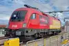 ÖBB Lokomotive der Rail Cargo Group mit Transporeon Branding auf elektrifizierter Bahnstrecke