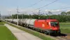 ÖBB Güterzug mit Kesselwagen fährt durch ländliche Landschaft