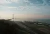 Bridge in Turkey spanning a coastal bay, with a port terminal and cranes along the shoreline