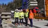 Vier Vertreter auf einer Baustelle mit Schutzhelmen und Warnkleidung vor Bahninfrastruktur