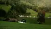 ÖBB Güterzug der Rail Cargo Group fährt durch eine grüne Hügellandschaft mit Wald und Wiesen